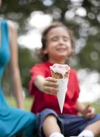 niño pequeño que sostiene el cono de helado