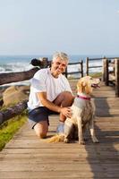 active senior man and his dog at the beach photo