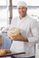 Happy baker with loaf of bread photo