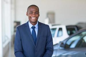 joven empresario africano en sala de exposición de automóviles foto