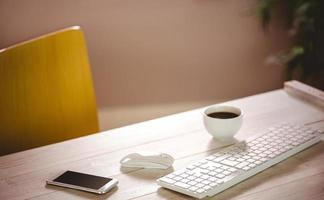 escritorio con teléfono con teclado y café