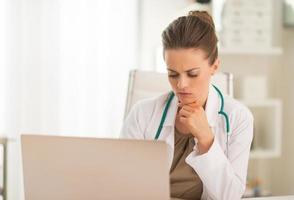 portrait of thoughtful medical doctor woman with laptop photo