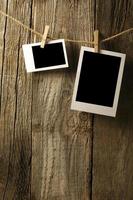 Blank photographs hanging on old wooden wall photo