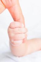 baby hand holding adult finger