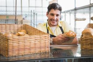 Smiling server in apron holding bread