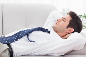 Businessman lying on sofa sleeping photo