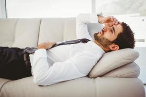 Sick businessman lying on the couch photo
