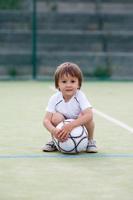 niño lindo, jugando al fútbol foto