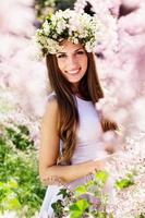 hermosa niña en la naturaleza en corona de flores foto