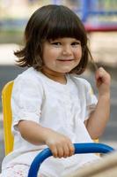 Cute little girl on swing in the playground photo