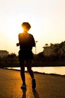 Runner athlete feet running on road. woman fitness silhouette su