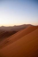 Sunrise above dunes in Namib Desert , Namibia photo