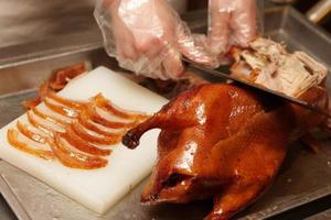 Chinese cook prepares Peking Roast Duck photo