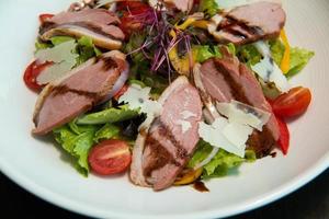 Salad with arugula and duck breast. photo