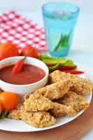 Chicken nuggets with tomato sauce photo