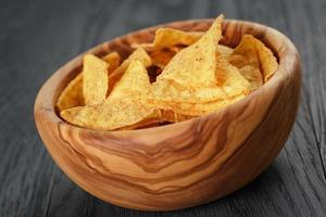 tortilla chips in olive wood bowl on wooden table