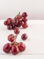 uvas rojas en mesa de madera foto