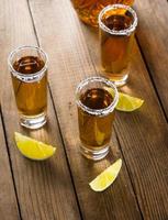 tequila en vasos de chupito con lima y sal foto