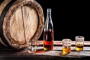 Three glass of aged whisky and bottle photo