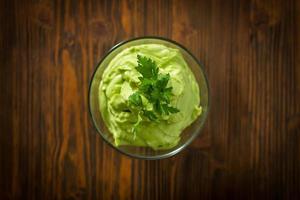 Guacamole on wooden table photo