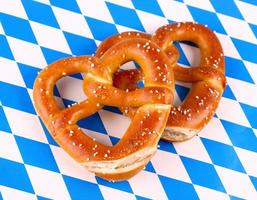 Two pretzel in heart shape on white blue background photo