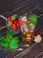 Strawberry mojito cocktail over wooden background