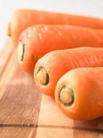 close up fresh and sweet carrot on wood plate photo