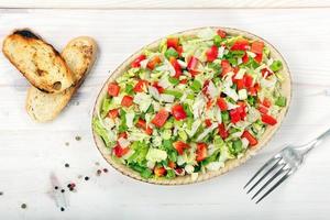 Fresh salad with peppers on wooden background