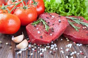 Raw beef steak with vegetables and spices photo