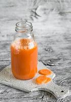 fresh carrot juice in a glass bottle photo