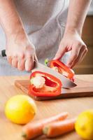 man cutting paprika in kitchen