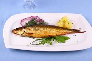 Kippers, smoked herring on a white plate with garnish photo