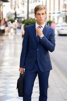 Attractive young businessman in urban background photo