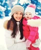 Retrato feliz sonriente madre e hijo en día de invierno cubierto de nieve