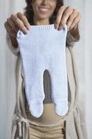 Pregnant Woman Holding Out Baby Pants photo