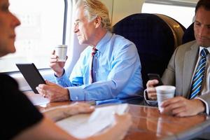 empresario relajante en tren con taza de café foto