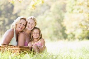 Grandmother with adult daughter and grandchild on picnic