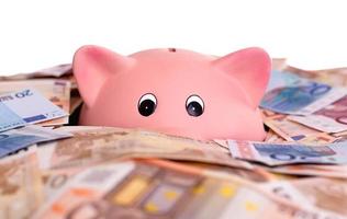 Unique pink ceramic piggy bank drowning in money photo