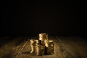 Piles of gold coins on a natural dark background photo