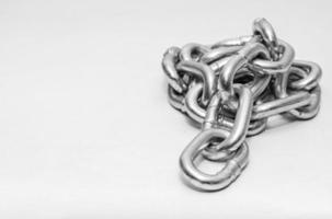 metal chain folded in a heap on white photo
