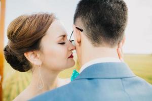 groom kissing bride in field photo