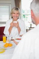 sonriente mujer madura desayunando con hombre recortado