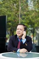 Asian businessman talking on smart phone photo