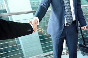 Handshake of businessmen at the airport - business travel concept