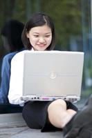 Young Asian female executive using laptop PC in business district photo