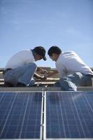 ingenieros trabajando en paneles solares en la azotea foto
