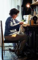 middle aged woman sewing photo