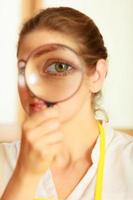 Woman looking through magnifying glass. photo