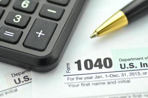 primer plano de nosotros formulario de impuestos, bolígrafo y calculadora foto