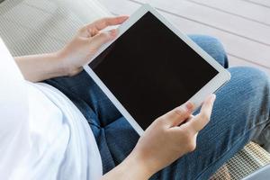 Woman hand hold white tablet with blank empty screen photo